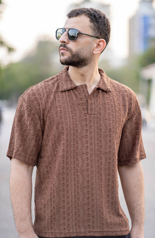Man wearing a brown patterned shirt outdoors